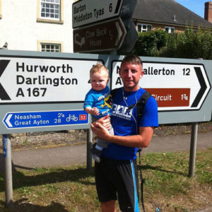 AFE widower holding a baby after 5K event.