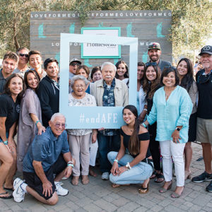 Groupr of AFE Foundation supporters with photo frame cut that read end AFE.