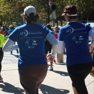 Two females running at AFE 5K event.