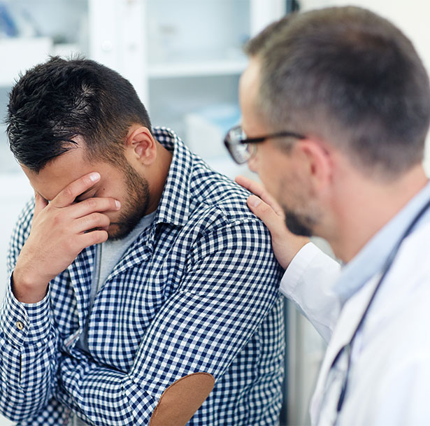 A worried man with a doctor at the hospital.