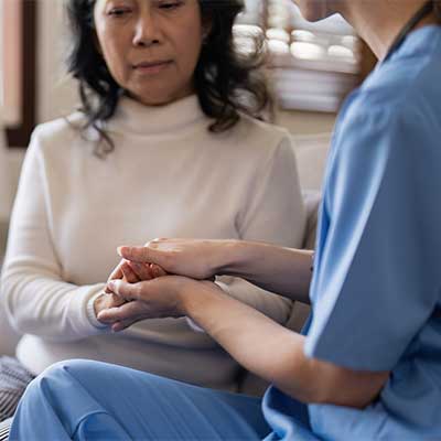 Nurse is consoling a worried family member, the mother.