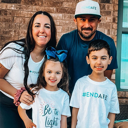 Parents and their two children wearing end AFE t-shirts.