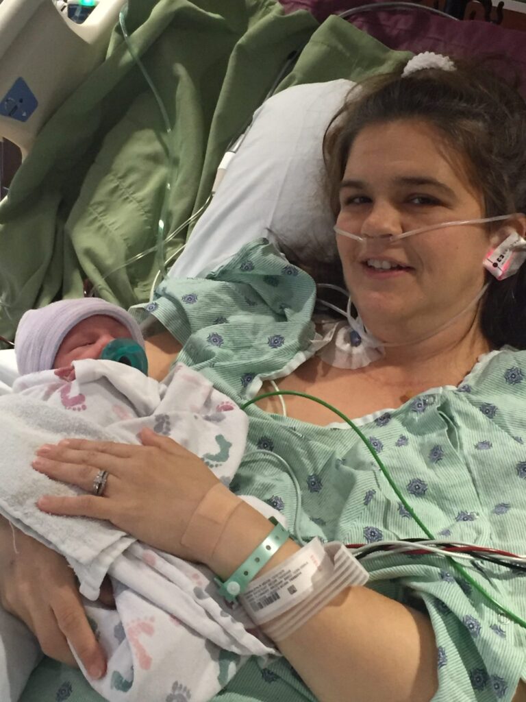 AFE Survivor, Erin Cranston, with her baby in a hospital bed.